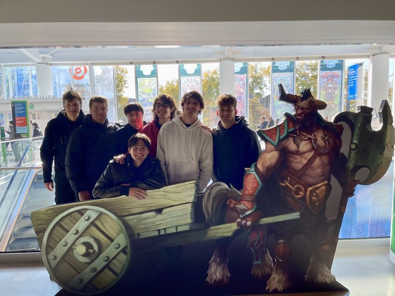 Tryfon with a group beside a Dota 2 character display