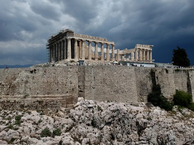 The Parthenon above the walls of the Acropolis beneath a cloudy sky