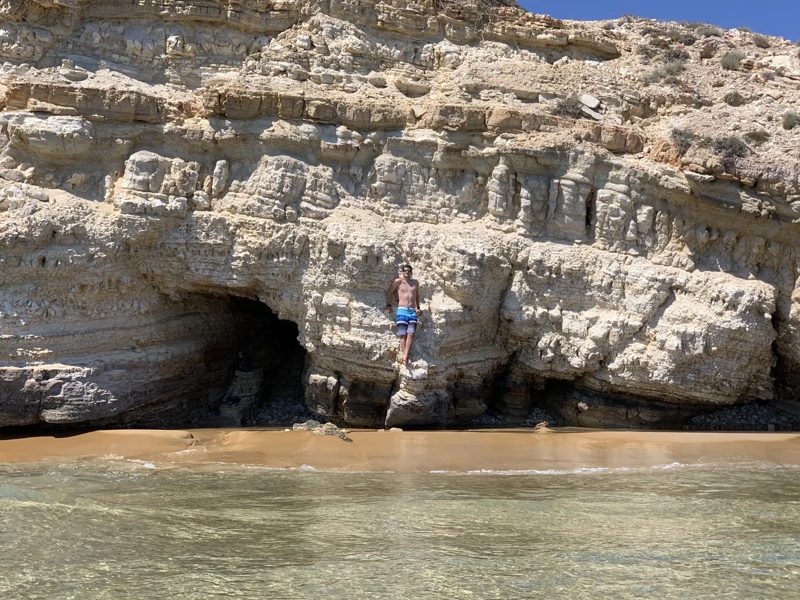 A rocky Greek coastline with a sea cave