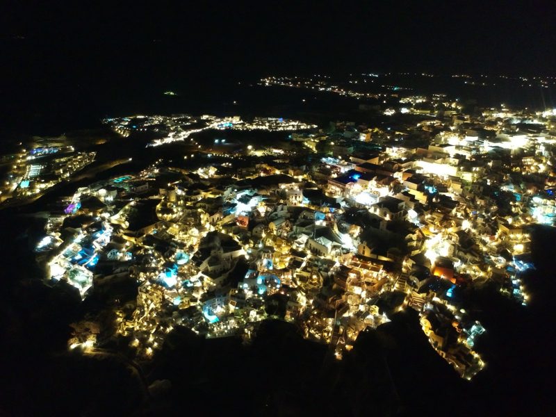 White buildings and pools glowing across a Greek town at night