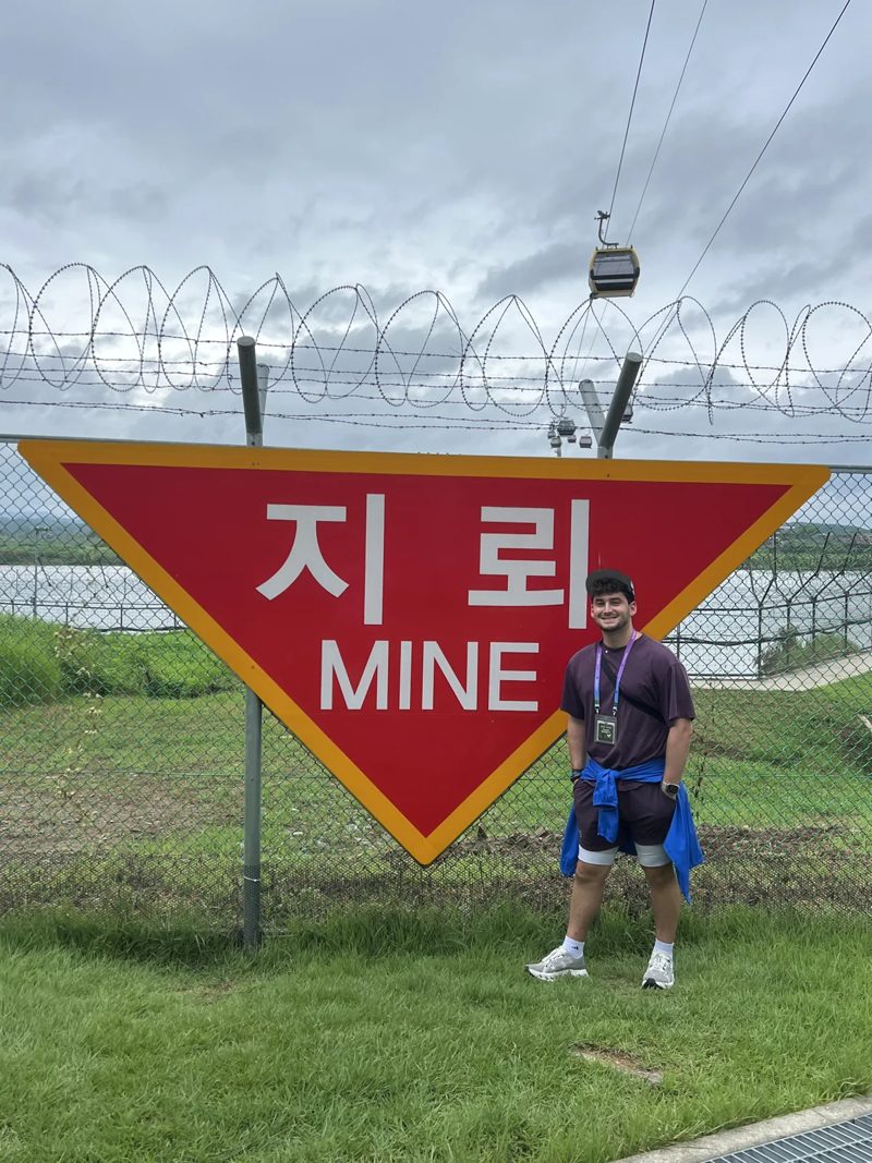 Tryfon near a cable car and a warning sign during a day trip in South Korea